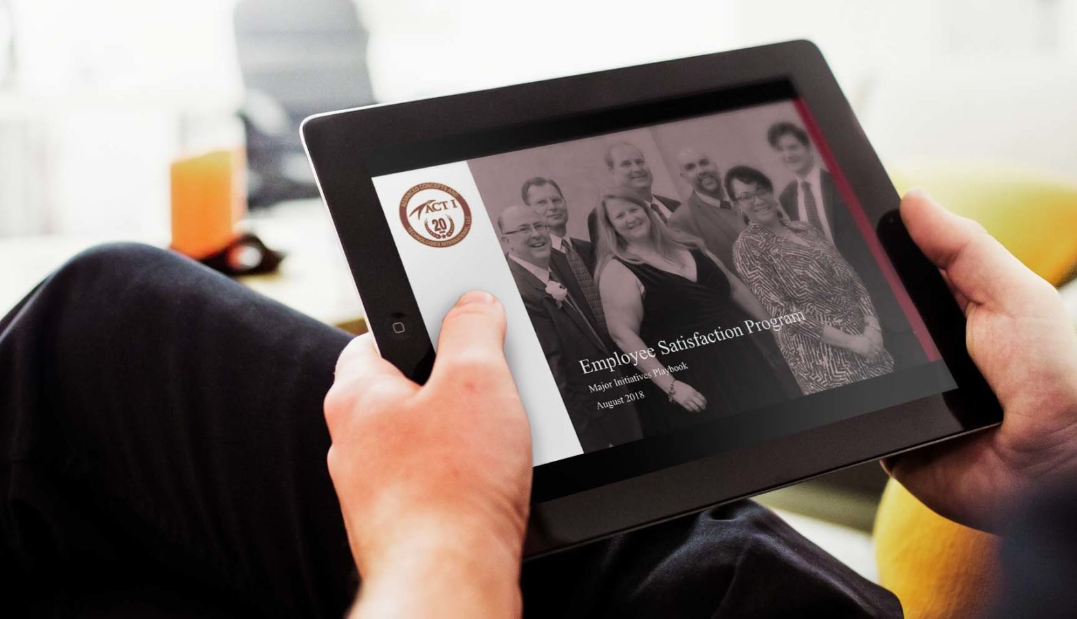 A person views an iPad with ACT I's Employee Satisfaction Program playbook on the screen